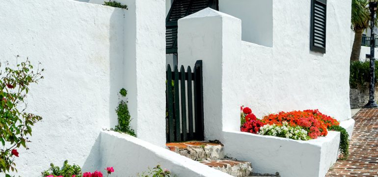 Brilliant flowerbeds along the stucco walls of foreign real estate in Bermuda.