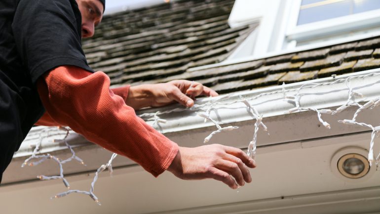 Professional holiday light installation along home gutter line.