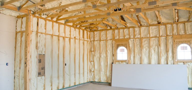 A garage ceiling and walls at a newly constructed home is sprayed with liquid insulating foam before the drywall is added.