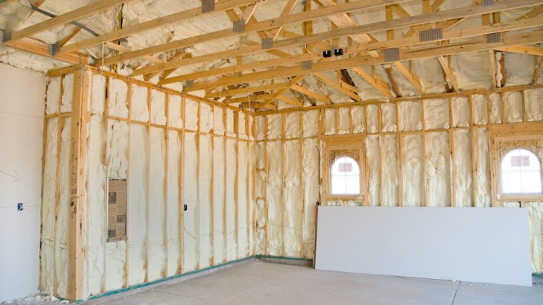 A garage ceiling and walls at a newly constructed home is sprayed with liquid insulating foam before the drywall is added.