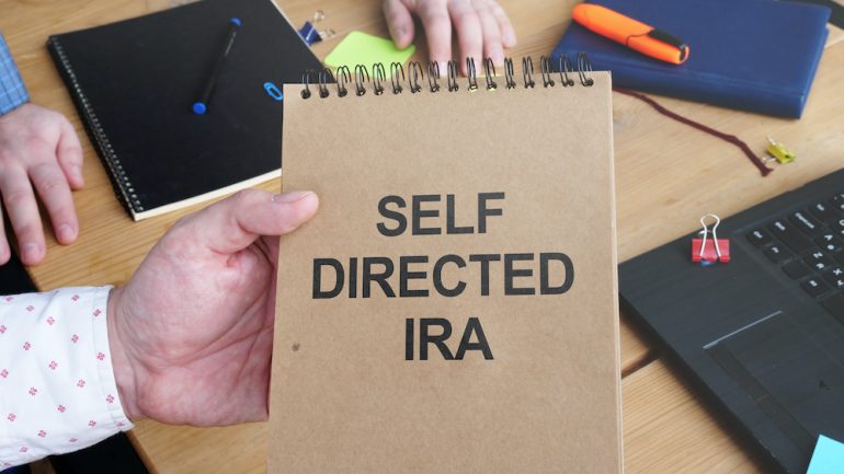 Business photo shows handwritten text self-directed IRA.