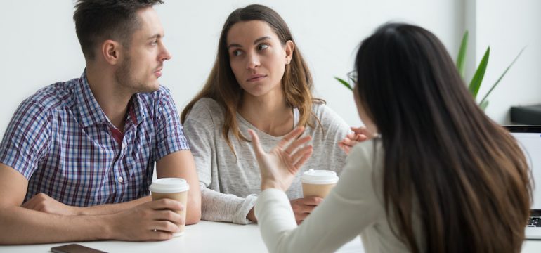 Couple looking at each other doubting offer from instant buyer.