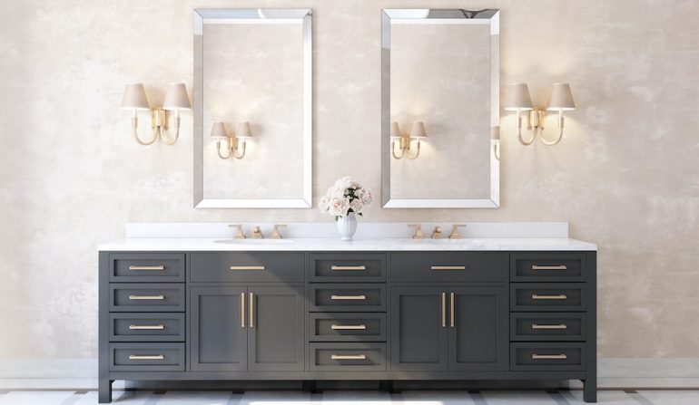 Classic luxury bathroom with marble floor, brass fixtures and dark vanity cabinets.