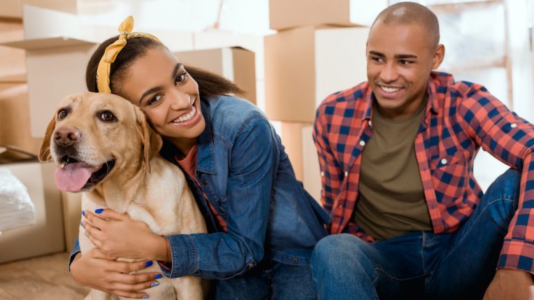 Happy African American family with labrador dog showing concept of repatriation to home country after living abroad.