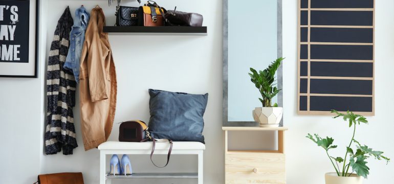 Functional entryway with large mirror, coat hooks and shoe rack.