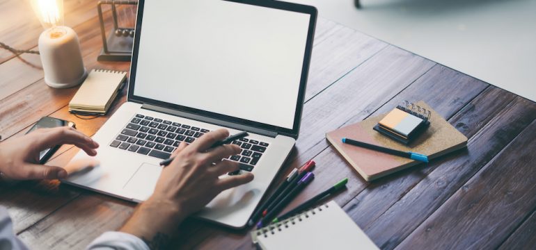 Male hands and laptop with blank screen to show concept of improving laptop speed.