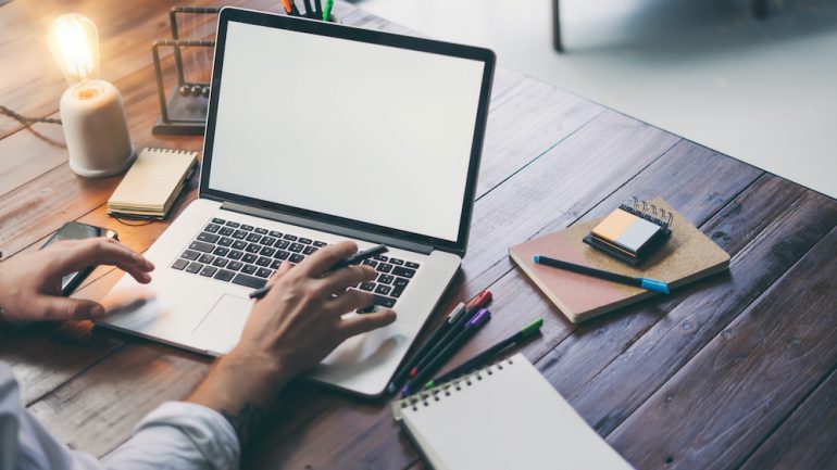 Male hands and laptop with blank screen to show concept of improving laptop speed.