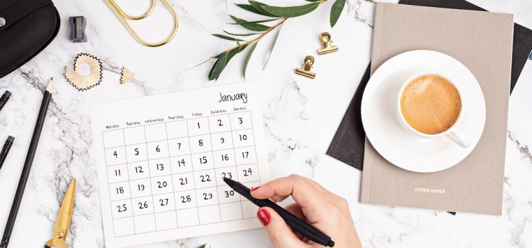 Desktop with calendar for January and office supplies. Home office, social media blog, schedule, planning concept.