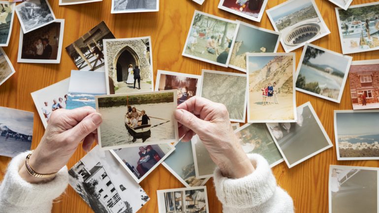 Top view of a senior caucasian woman sorting old photos. A task on her February to-do list.