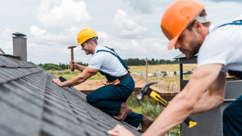 Focus of two handyman repairing a roof which is a major home system.