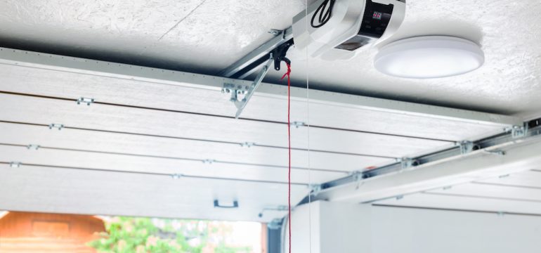 Troubleshooting automatic garage door opener problems. Electric engine gear mounted on ceiling with emergency cord.
