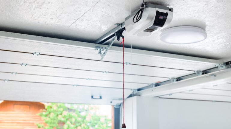 Troubleshooting automatic garage door opener problems. Electric engine gear mounted on ceiling with emergency cord.