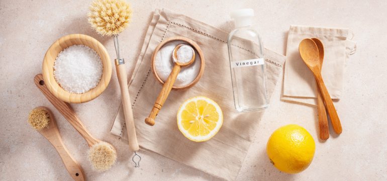 Eco friendly cleaning concept. Photo of wooden brushes, lemon, baking soda, and cleaning with vinegar.