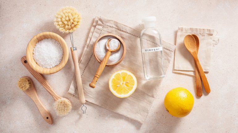 Eco friendly cleaning concept. Photo of wooden brushes, lemon, baking soda, and cleaning with vinegar.