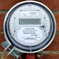 Image of electrical power meter on outside wall of brick wall calculating the idle load drawn by the home.