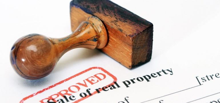 Sale of real property form with stamp of approval demonstrating transfer of clear title on a property.