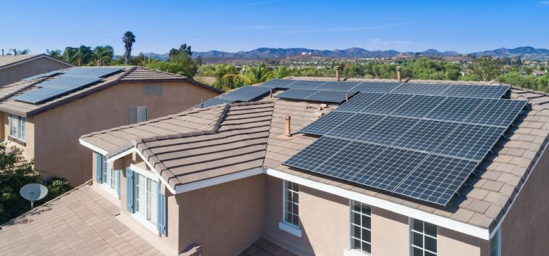 Solar energy panels installed on the roof of a large house.