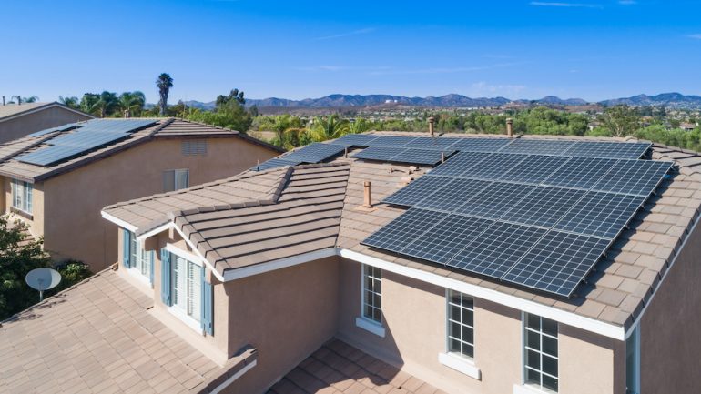 Solar energy panels installed on the roof of a large house.