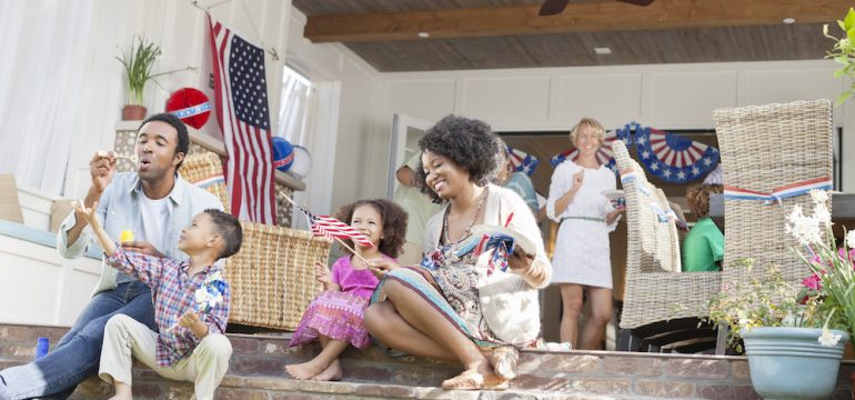 Family celebrating 4th of July on a front porch.