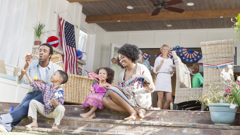 Family celebrating 4th of July on a front porch.