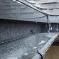 Jets of rain drain into the drainage system on the roof of the house. Homeowners need to protect their homes against mother nature's wrath.