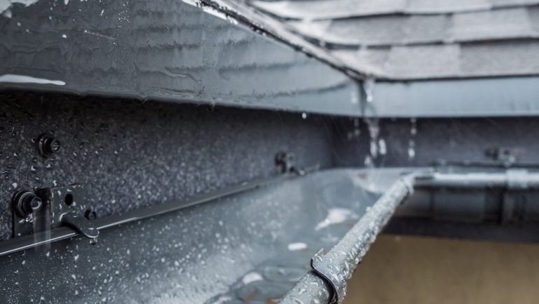 Jets of rain drain into the drainage system on the roof of the house. Homeowners need to protect their homes against mother nature's wrath.