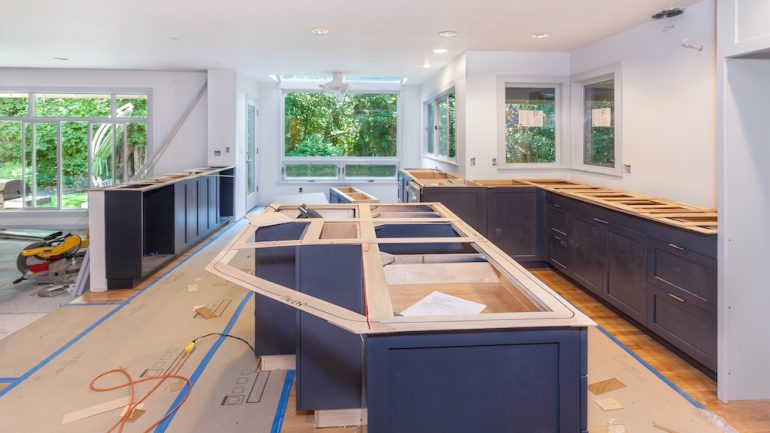 Cutting and marking wood templates for making countertops in kitchen remodel.