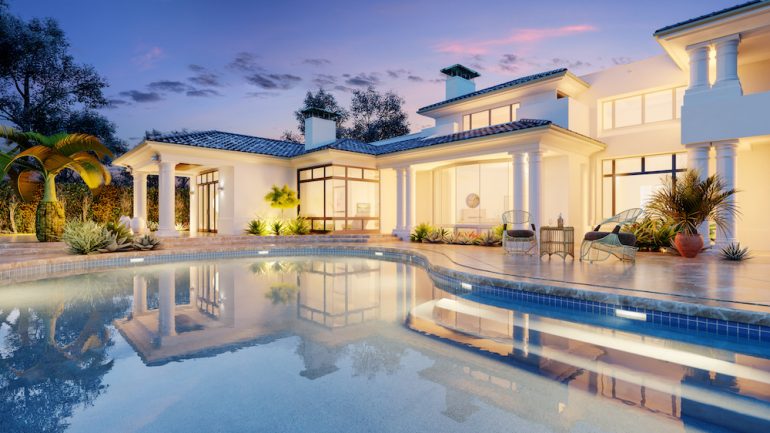 An expensive bigger house with a swimming pool in the evening.