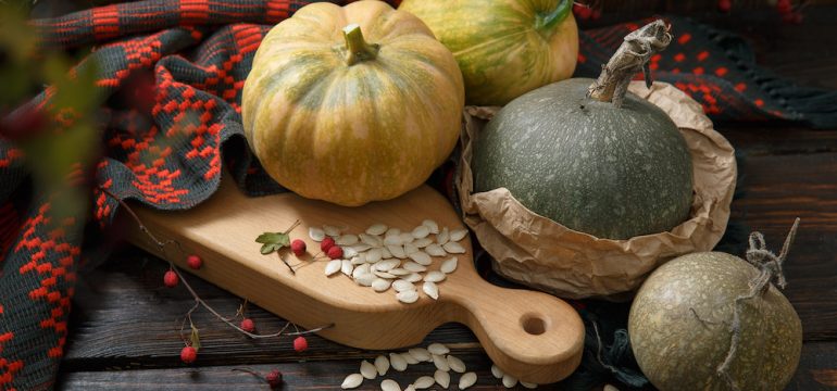Different pumpkins on wooden background. Gathering food for the holidays.