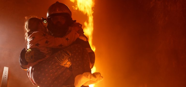 Brave fireman carries girl downstairs in a burning home with open fire after he found her behind a closed bedroom door.