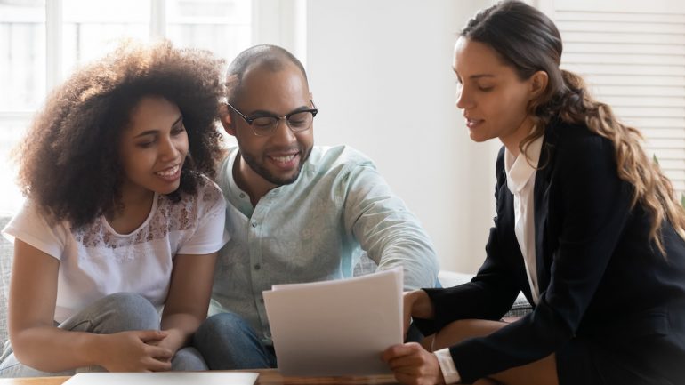 Couple at meeting with a REALTOR discussing contract terms.