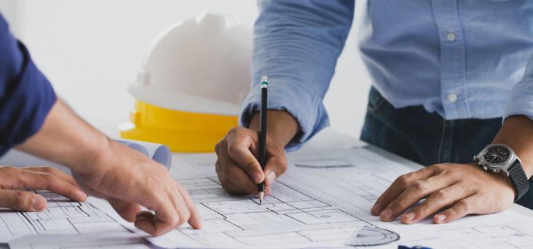 The general contractor for a construction project working with a partner at a desk in a home office.