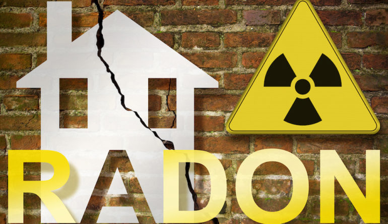 The danger of radon gas in our homes - concept with an outline of a small house with radon text against a damaged, cracked brick wall and radiation hazard sign.