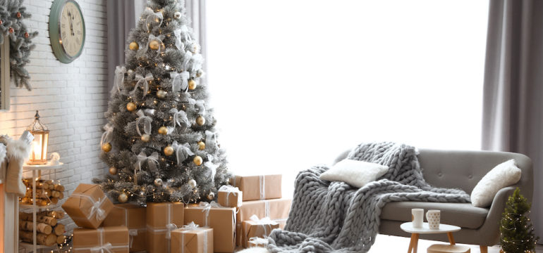 Stylish interior of living room with decorated sustainable Christmas tree and gift wrap.