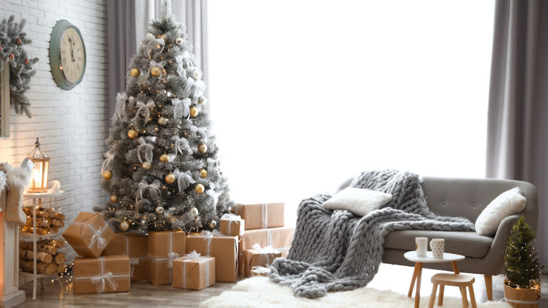 Stylish interior of living room with decorated sustainable Christmas tree and gift wrap.