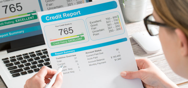 A woman reviewing her credit report showing a good credit score of 765.