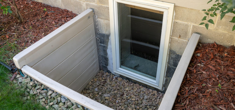 Exterior view of an egress window in a basement bedroom. These windows are required as part of the USA fire code for basement bedrooms.