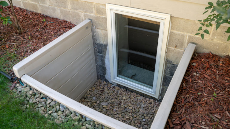 Exterior view of an egress window in a basement bedroom. These windows are required as part of the USA fire code for basement bedrooms.