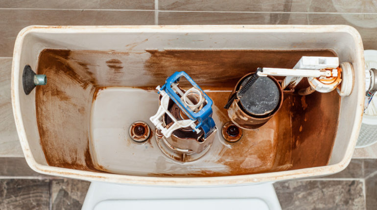 Top view on the inside of the toilet flushes tank. Float and fittings of the toilet flush mechanism.