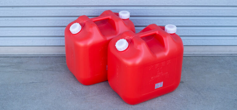 Two red gasoline plastic storage tanks for home storage..