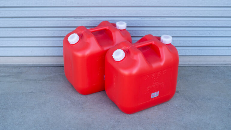 Two red gasoline plastic storage tanks for home storage..
