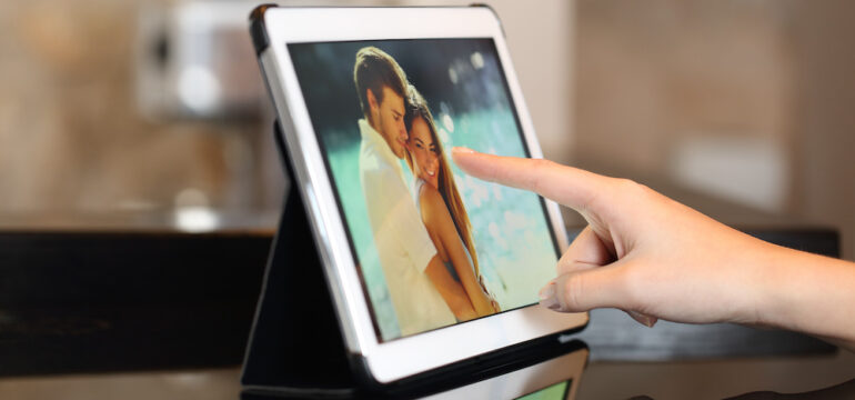 Woman hand using digital photo frames to view family pictures.