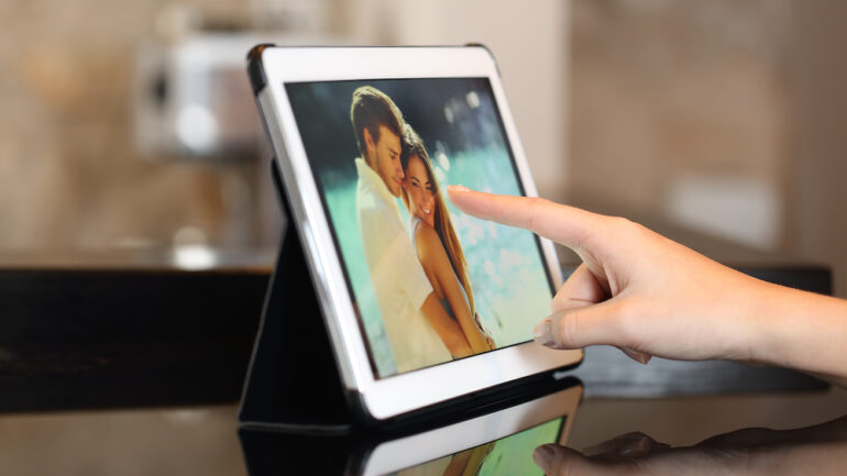 Woman hand using digital photo frames to view family pictures.