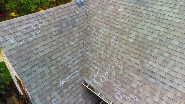 Roof damage from hail with chalk markings from inspection.