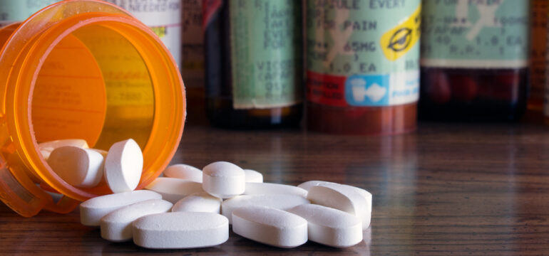 Prescription bottles with tablets that require proper medication disposal.