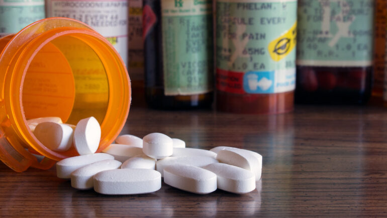 Prescription bottles with tablets that require proper medication disposal.