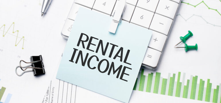 The text on the photo is rental income. Written words on a paper notebook to present the vacation rental concept.