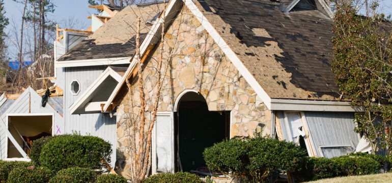 The roof of this wood frame and stone house was destroyed by this natural disaster. A reputable roofing contractor is needed for repairs.