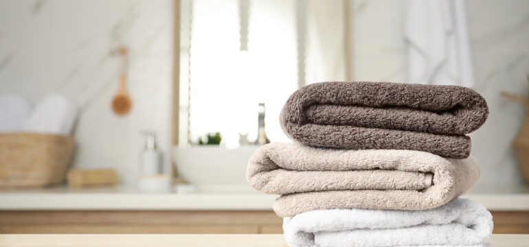 Fresh towels on the wooden table in the bathroom made of OEKO-TEX®.