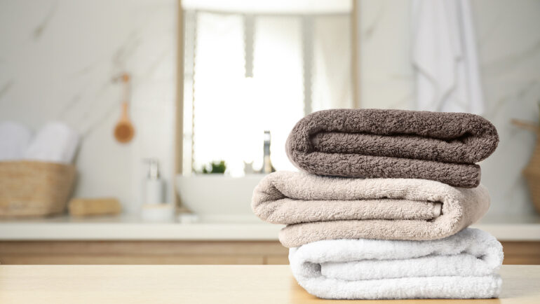 Fresh towels on the wooden table in the bathroom made of OEKO-TEX®.